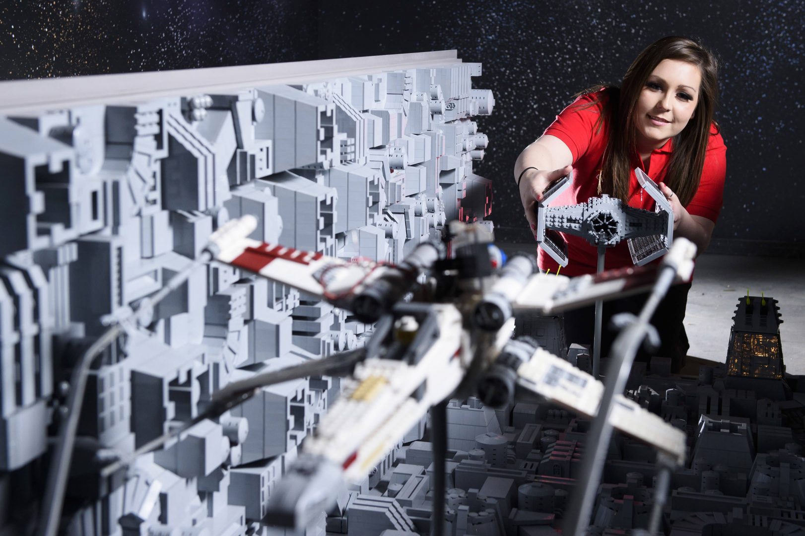 ONE OF THE WORLD’S BIGGEST EVER LEGO® STAR WARS™ MODELS INSTALLED AT THE LEGOLAND® WINDSOR RESORT. LAST PIECES PUT IN PLACE IN NEW LEGO® Star Wars™ Miniland Model Display Finale.  LEGOLAND® Model Maker Phoebe Rumbol, puts the finishing touches to some of the Rebel Alliance ships featured in a new finale scene to the Resort’s LEGO® Star Wars™ Miniland Model Display. This is one of the smaller elements to the 651,086 brick scene and the centre piece is one of the most impressive and biggest LEGO® Star Wars™ models ever created - a 500,000 brick LEGO® Star Wars™ recreation of The Death Star.   The models were installed in a mammoth operation that took three days as the massive new 2.4 metre wide, 3 metre high creation was carefully hoisted into position and the final bricks and scenes were put in place. The hefty 860kg perfectly spherical model took 15 Model Makers three months to build and guests can trigger special effects and bring the scene to life when it opens at the Resort on 11 March.  TM & © Lucasfilm Ltd. All rights reserved