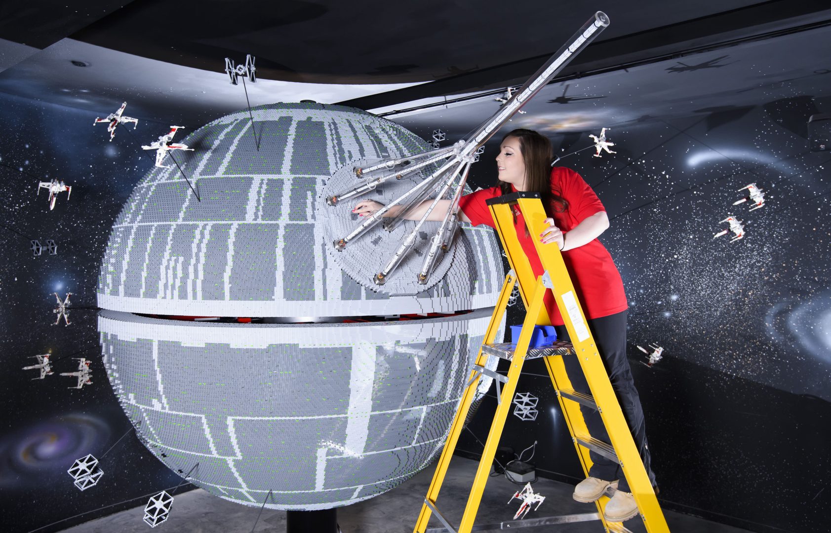 ONE OF THE WORLD’S BIGGEST EVER LEGO® STAR WARS™ MODELS INSTALLED AT THE LEGOLAND® WINDSOR RESORT.   LAST PIECES PUT IN PLACE ON 500,000 LEGO® BRICK DEATH STAR LEGOLAND® Model Maker, Phoebe Rumbol, puts the finishing touches to one of the most impressive and biggest LEGO® Star Wars™ models ever created as a 500,000 brick LEGO® Star Wars™ recreation of The Death Star is installed in a new finale to the Resort’s LEGO® Star Wars™ Miniland Model Display. The operation took three days as the massive new 2.4 metre wide, 3 metre high creation was carefully hoisted into position and the final bricks  were put in place. The hefty 860kg perfectly spherical model took 15 Model Makers three months to build and  guests can trigger special effects and bring the scene to life when it opens at the Resort on 11 March.  TM & © Lucasfilm Ltd. All rights reserved